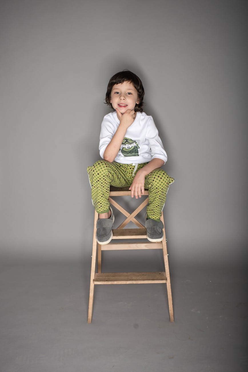 little boy sitting on stool