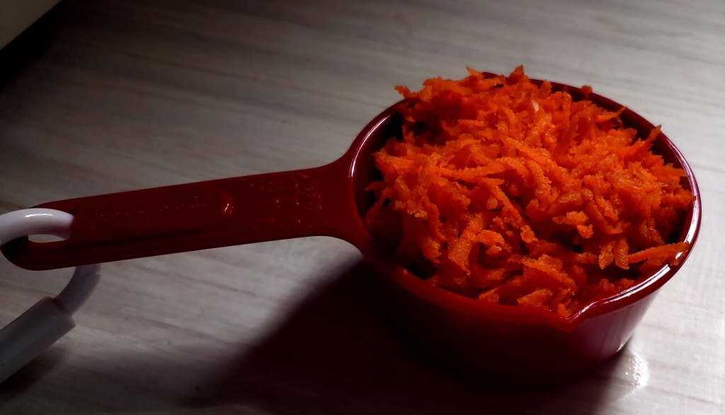 measuring cup fill with grated carrots