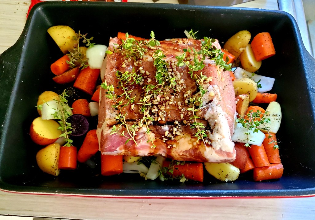 Pork roast on vegetables with herbs