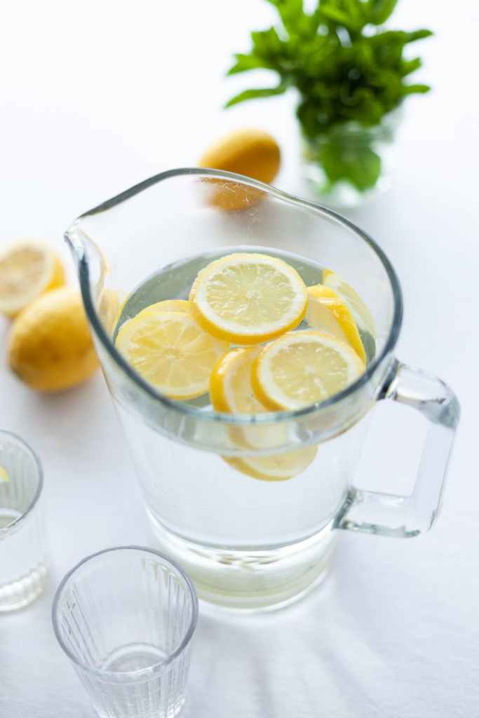 sliced lemons in a pitcher of ice water
