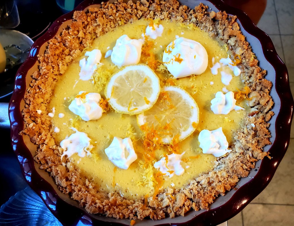 Final pie with whipped cream, lemon slices and lemon and orange zest
