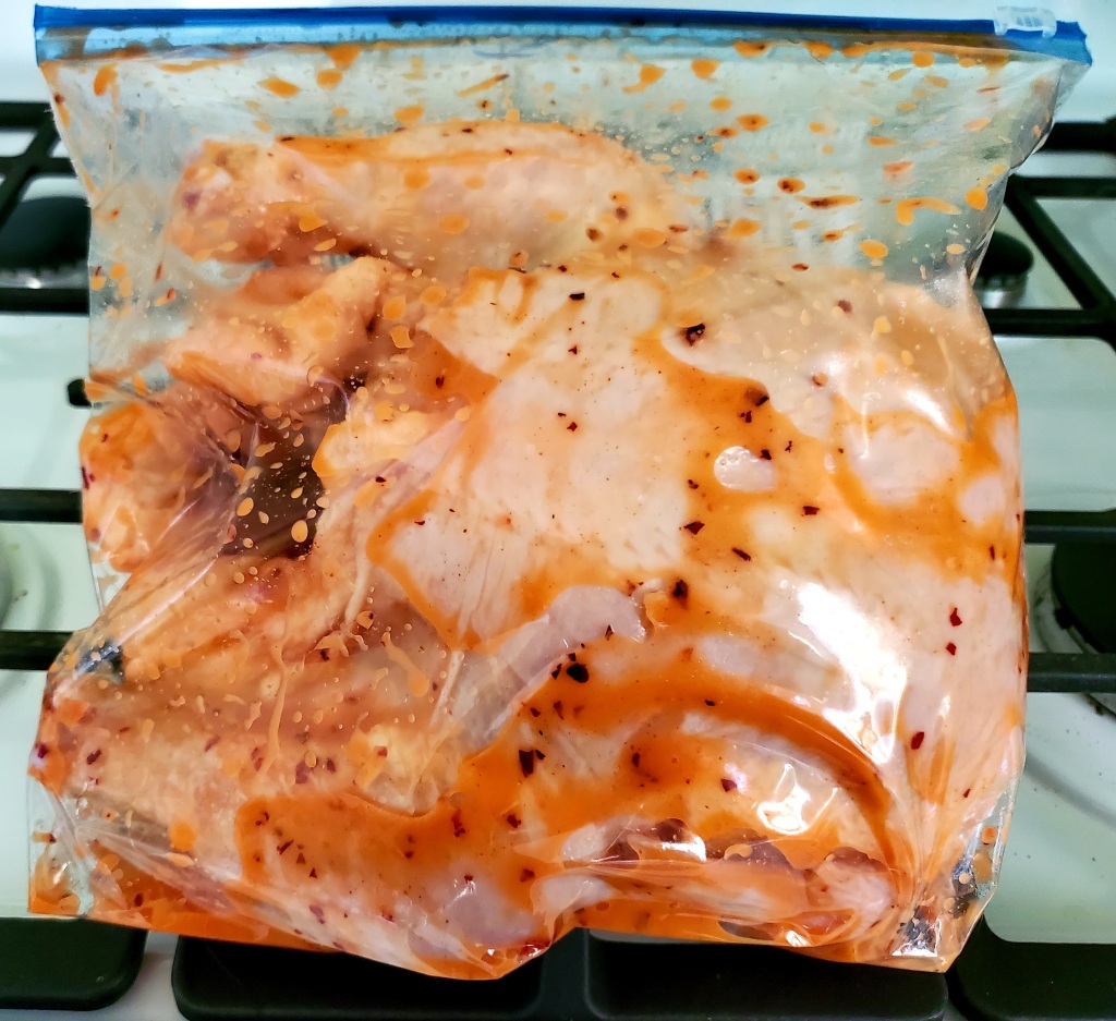 whole chicken with marinade in the zip lock bag