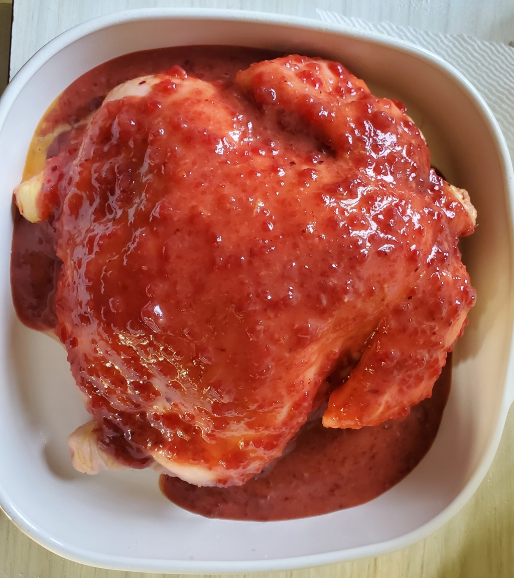 Chicken covered with cranberry lemon sauce before cooking