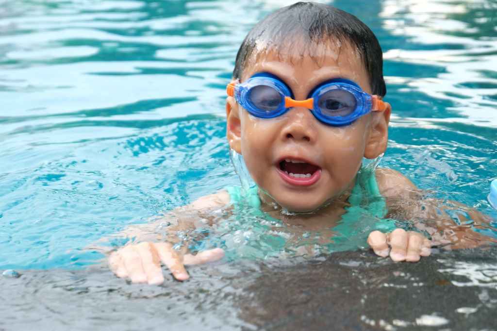 Small boy in a pool wearing goggles