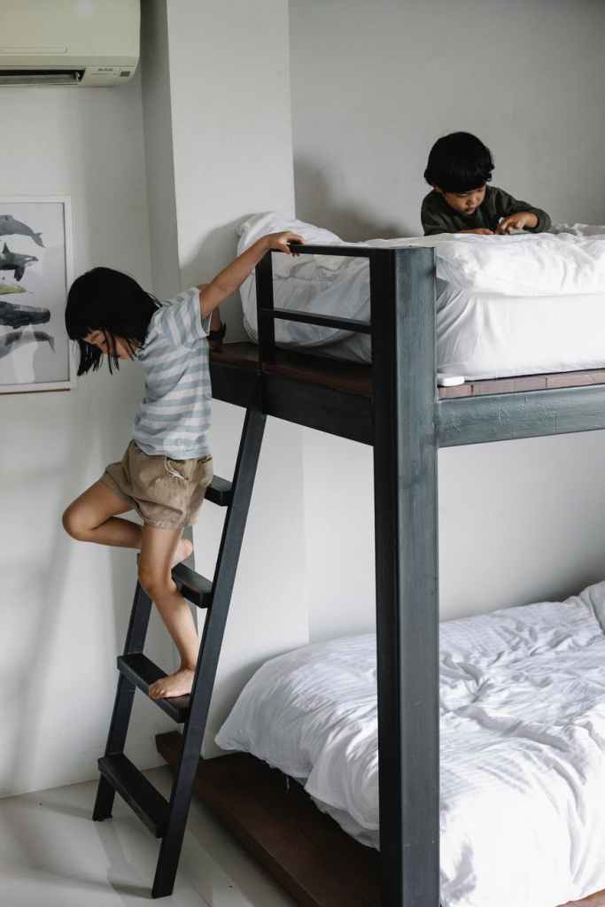 Girl climbing down ladder from bunk bed