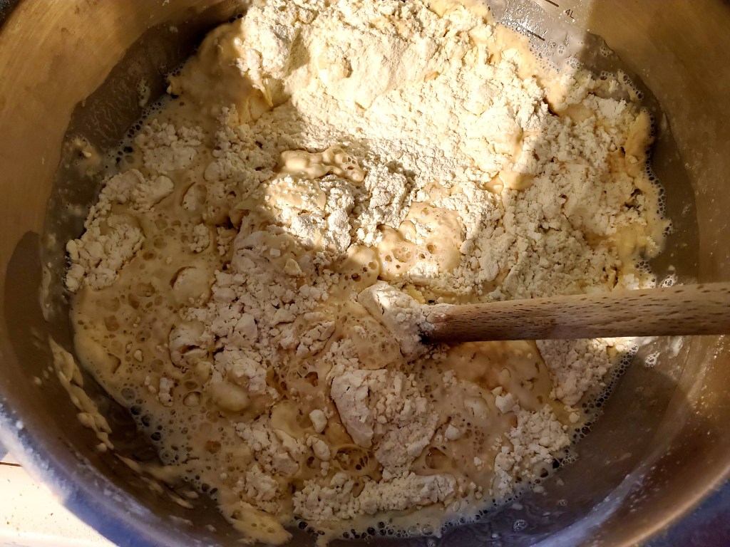 Dry ingredients and water being mixed with a spoon