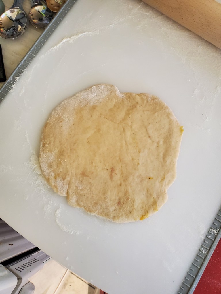 1 ball of dough flattened into a rough circle